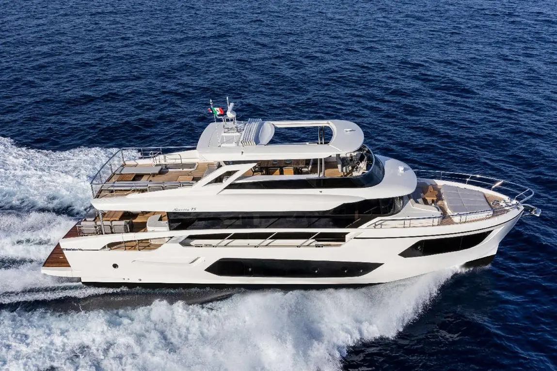 Luxury yacht cruising through deep blue water, showcasing a sleek design and spacious deck areas.